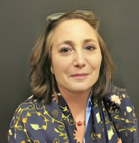 Elizabeth Levine, wearing glasses pushed up on her head and a patterned scarf, looking straight at the camera